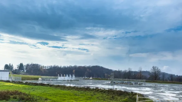 A gravel lot in a field with industrial equipment.