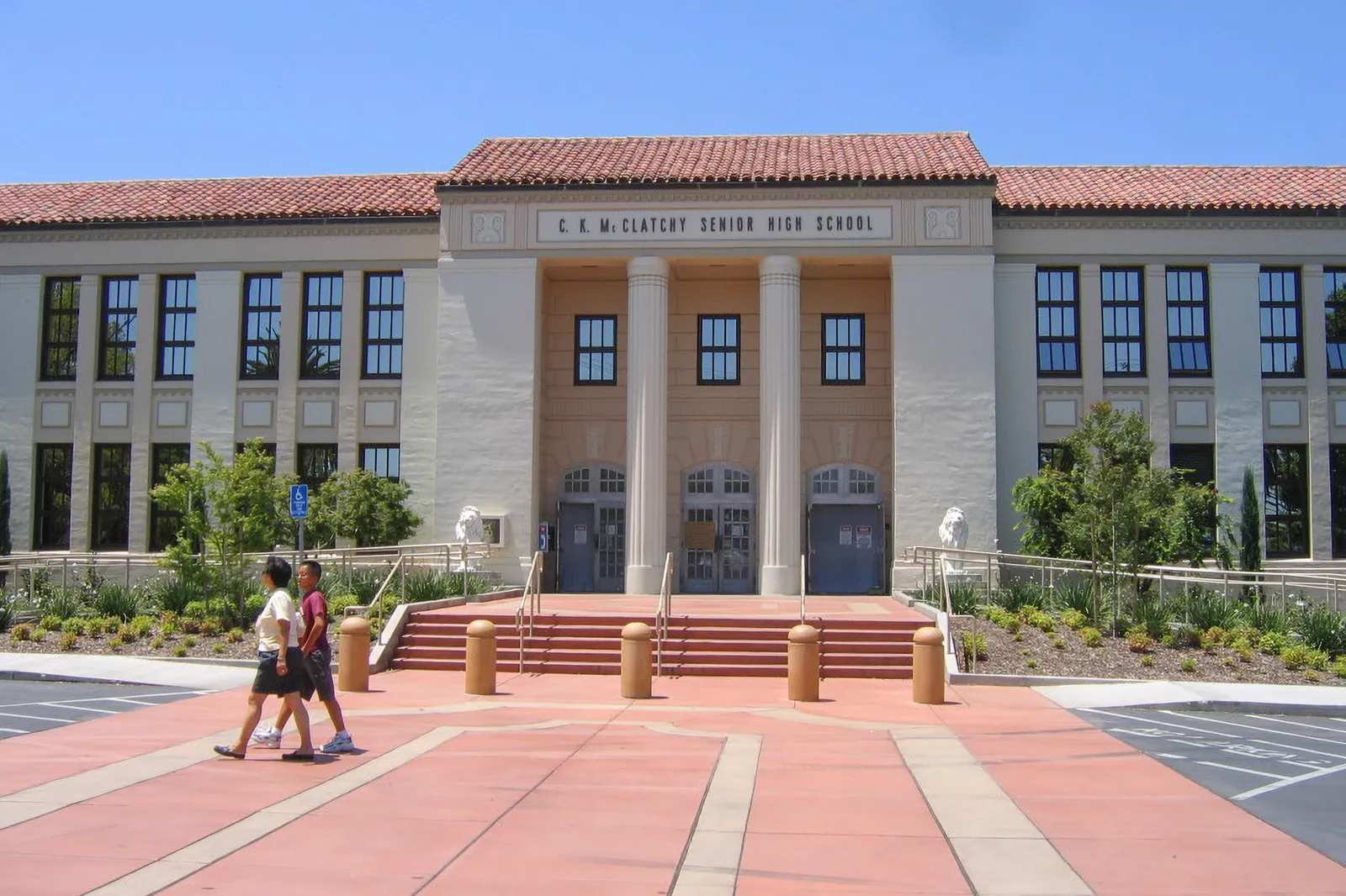 The exterior of CK McClatchy High School is shown with pedestrian crossing in front of the building