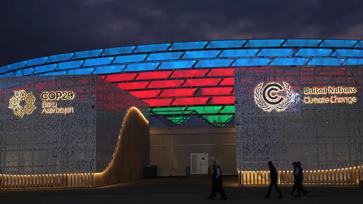 The COP29 stadium in Baku, Azerbaijan illuminated with green red and blue lights.