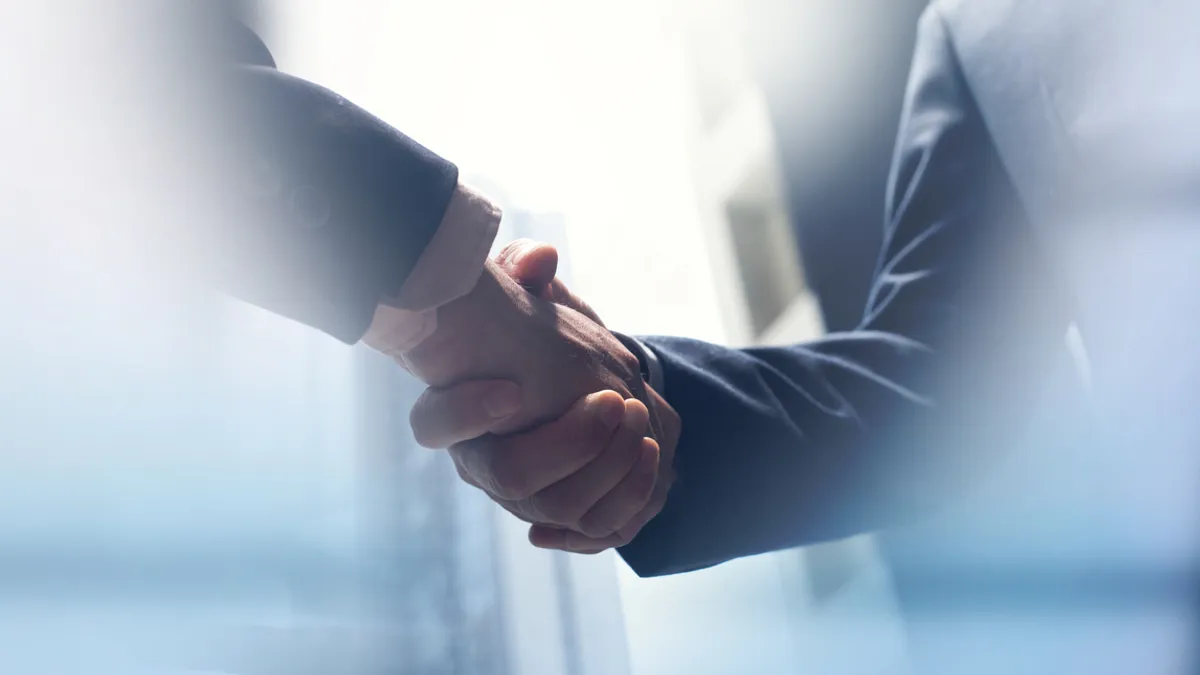 Two people shake hands in a stock photo.