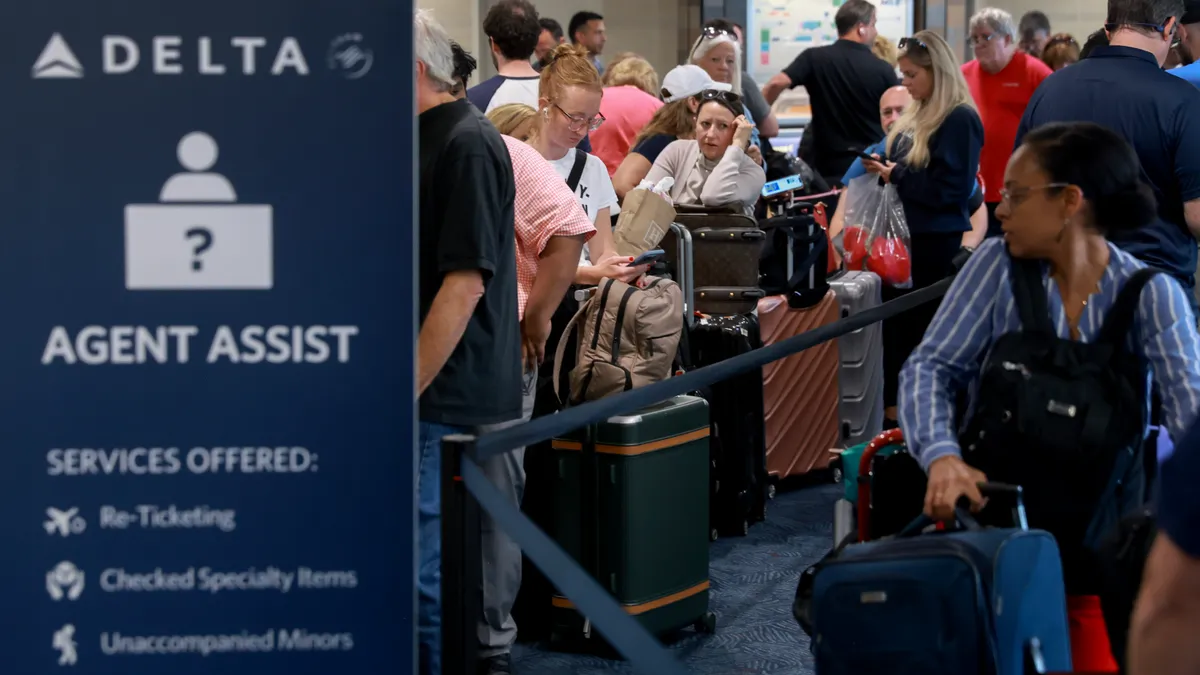 Customers stand in line at an airport.