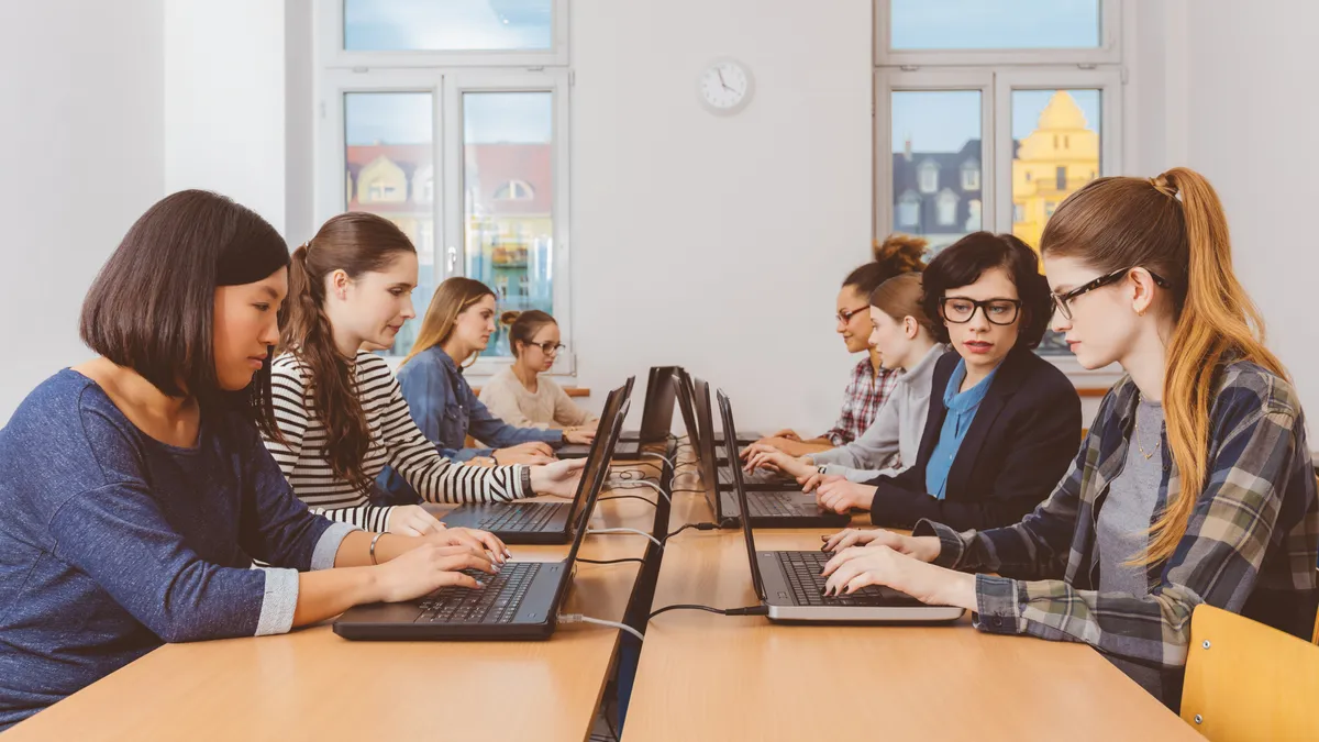 Girls in computer lab coding on laptops