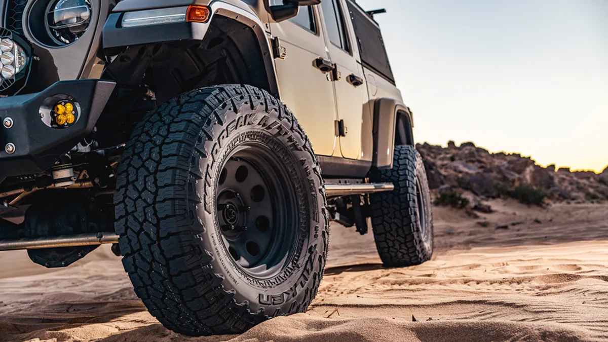 A closeup on the tires of a jeep in a desert.