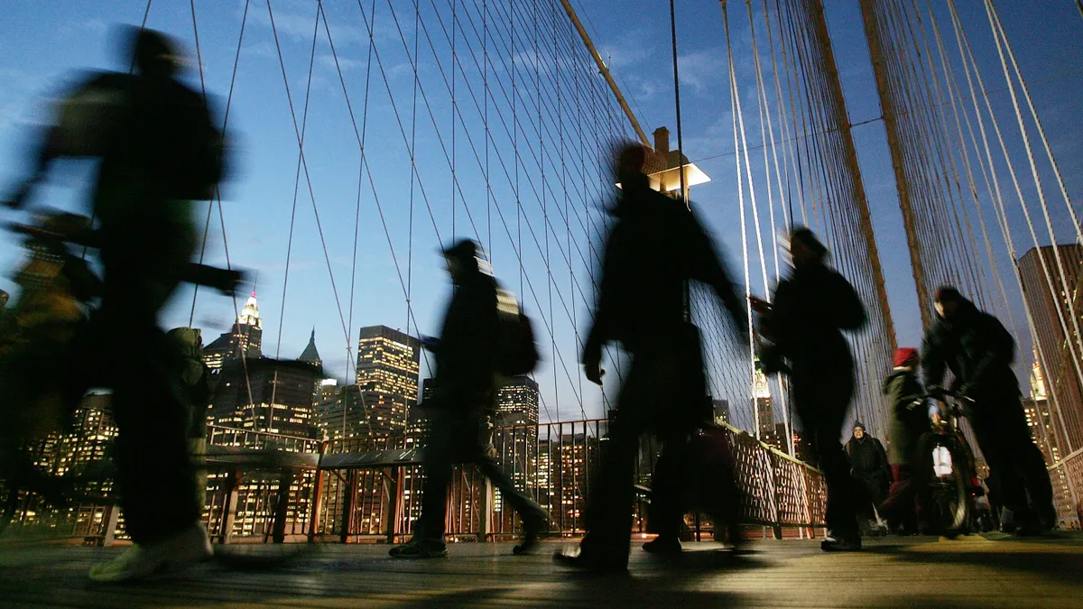 Commuters walk Brooklyn Bridge