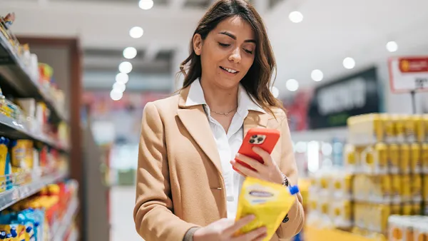 Woman taking a picture of a product at the grocery store