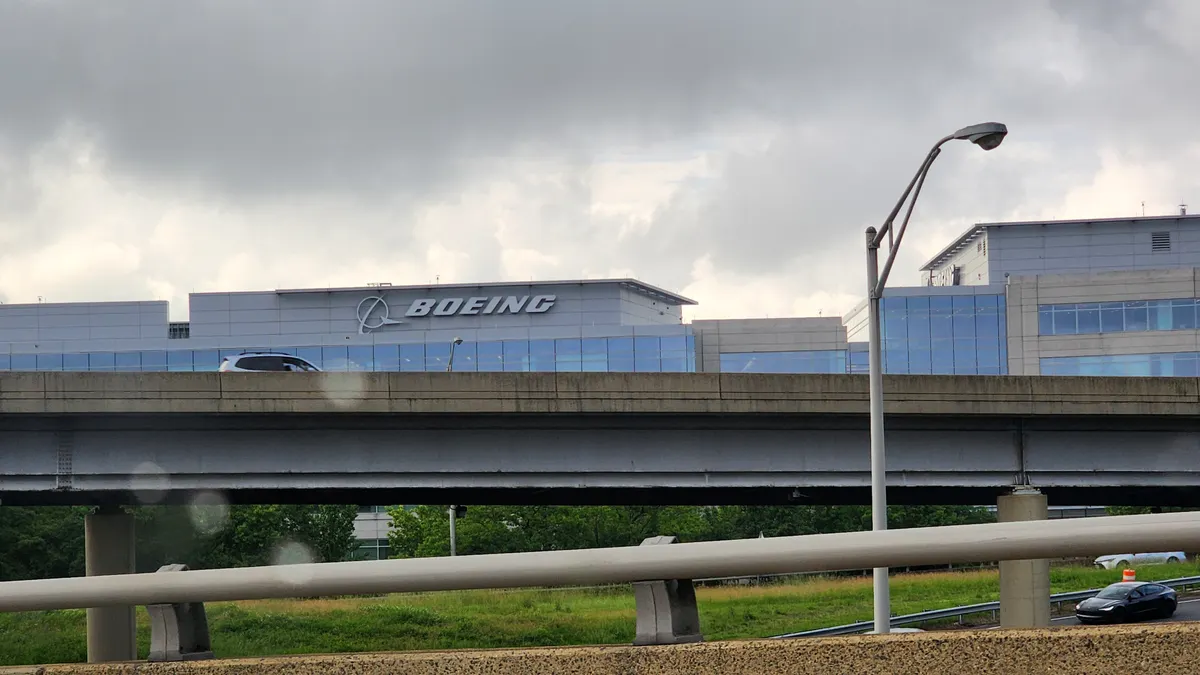 A building in the background with the white Boeing sign and logo on the front.