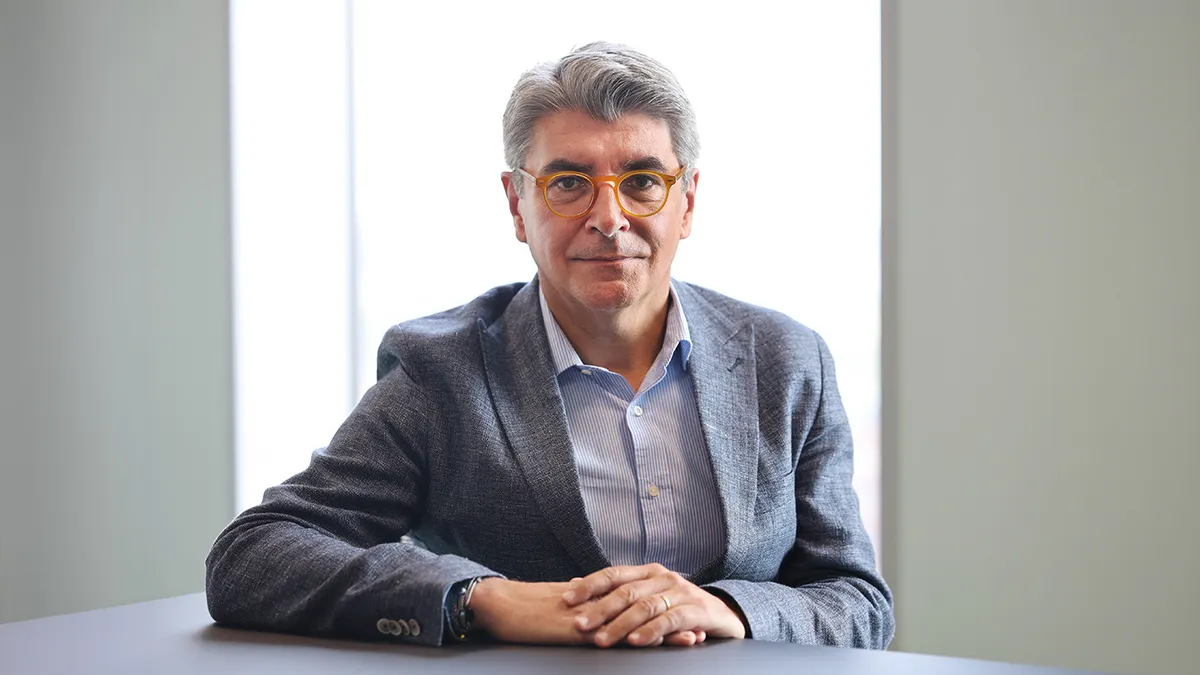 A man in a blazer sits at a table