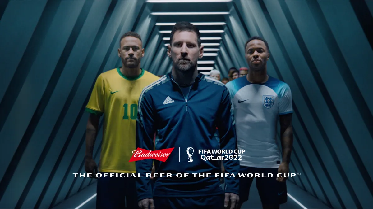 Lionel Messi, Neymar Jr. and Raheem Sterling stand together with a crowd of people behind them in the players tunnel.