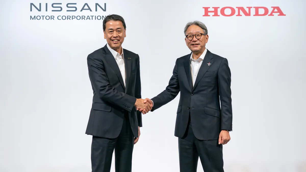 Nissan preisdent Makoto Uchida and Honda president Toshihiro Mibe shake hands at a press event announced the collaboration.