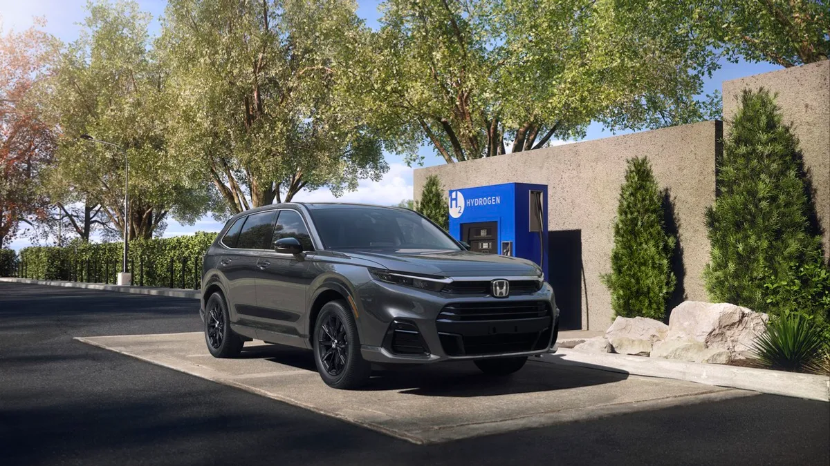 The 2025 Honda, CR-V eFCEV parking at a hydrogen refilling station with tress in the background.