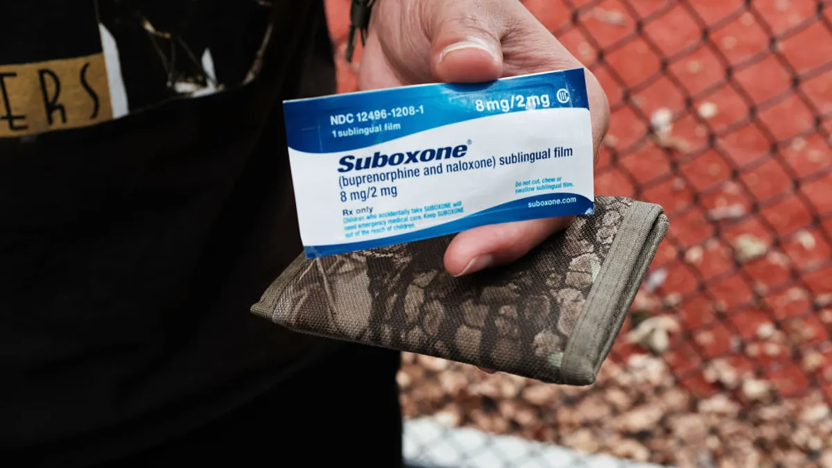 A close up of a box of Suboxone and a camo wallet