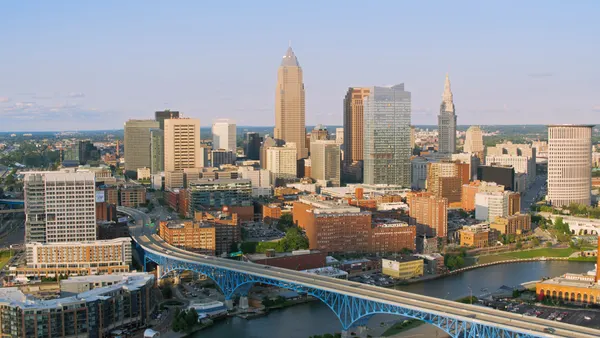 A bustling downtown skyline featuring an iconic blue bridge and clear skies.
