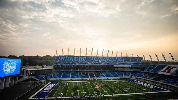 A rendering shows a completed college football stadium backlit by sunlight.