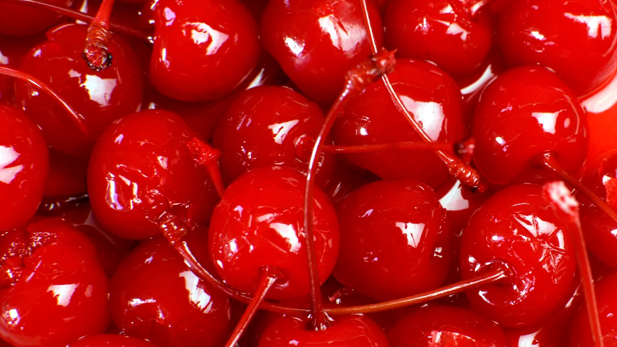 Several glossy maraschino cherries with stems