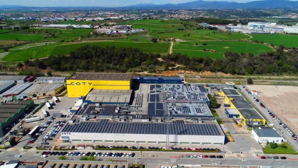 A yellow factory with the logo of Coty.
