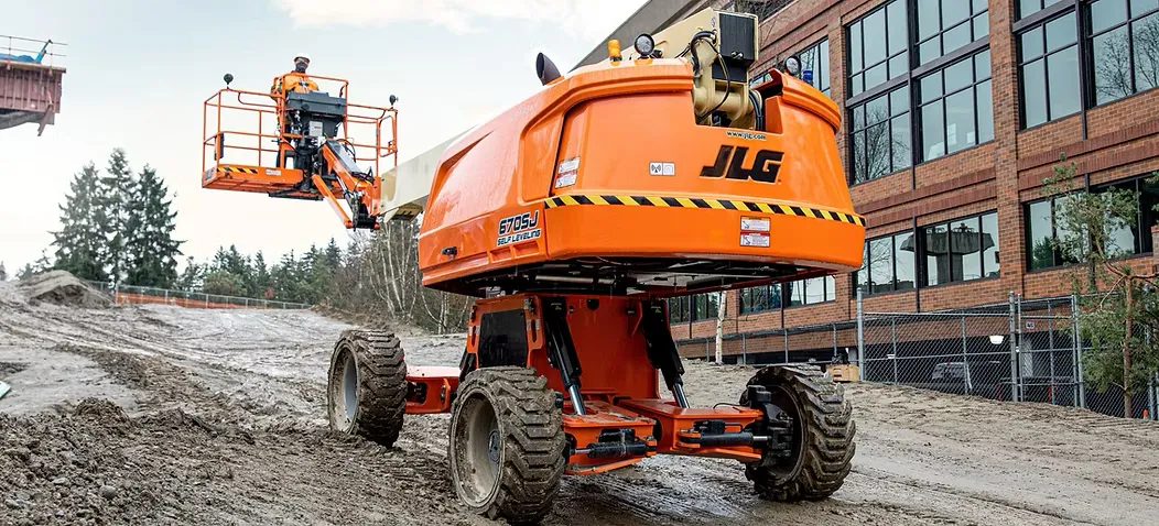 A self-leveling boom lift works on a construction site.