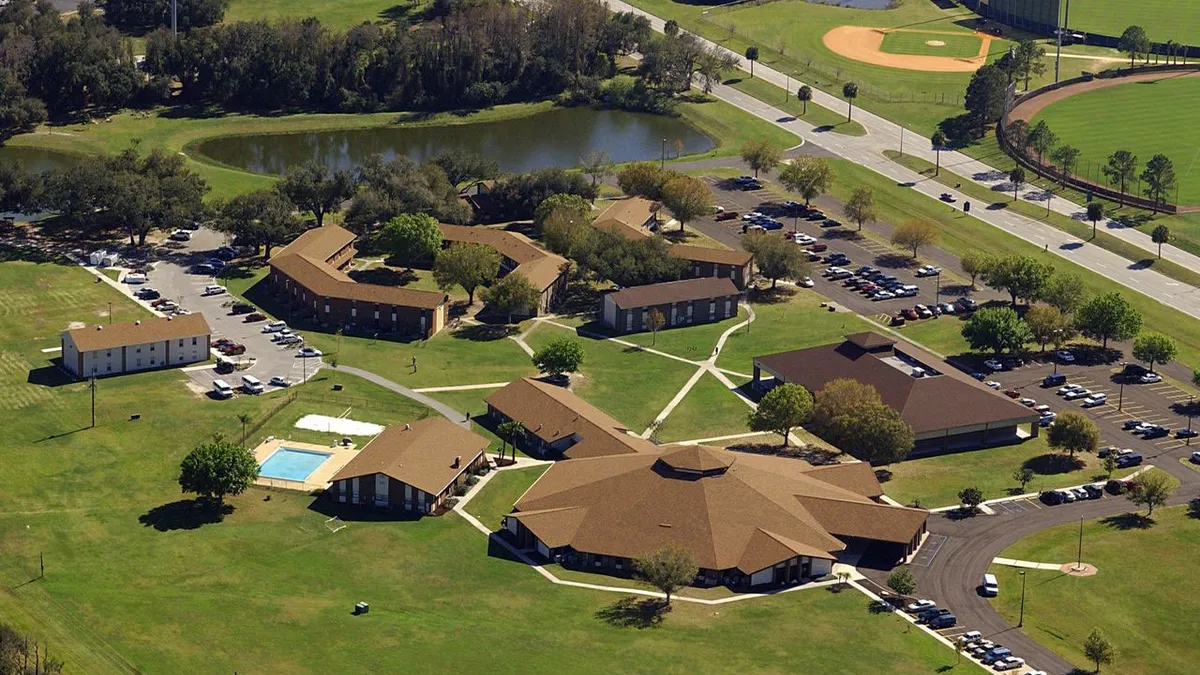 An aerial view of a warm-weather college campus with an outdoor pool and a baseball field.