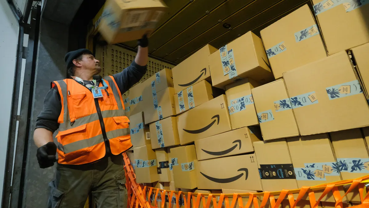 A worker loads a truck with Amazon packages.