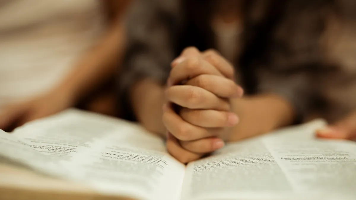 A close up view of a child reading the Bible.