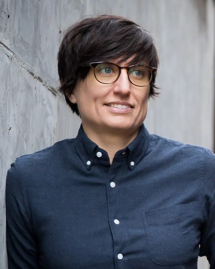 Headshot of a woman with short brown hair and a blue shirt.