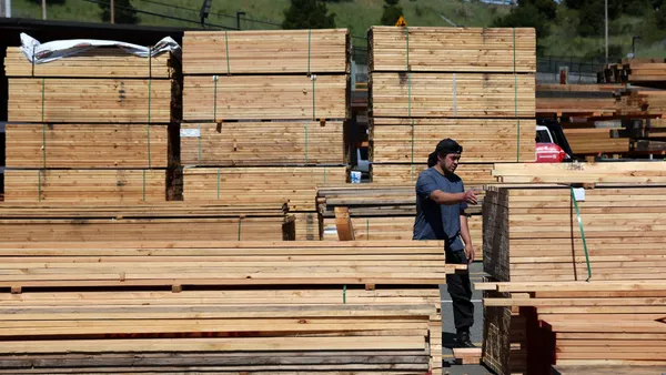 A customer looks through a stack of lumber.