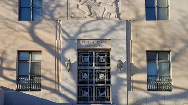 A building designed in the Classical Revival style features a limestone façade entrance with the Federal Trade Commission written in metal above the door. 
