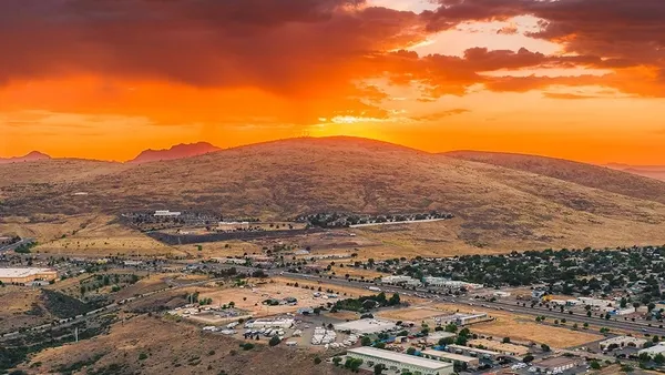 A hill seen at a distance with buildings below