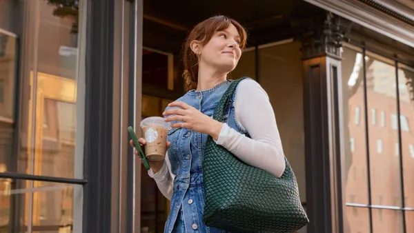 A smiling white woman with a Starbucks cup.