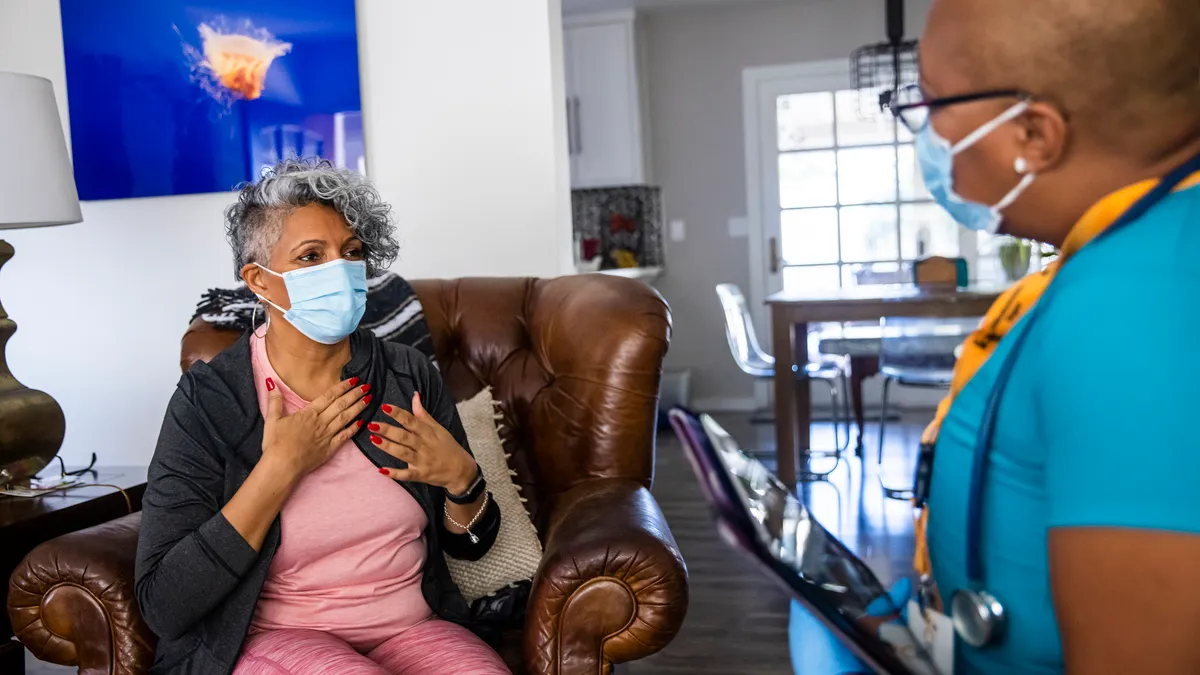 A woman being visited by a nurse in her home