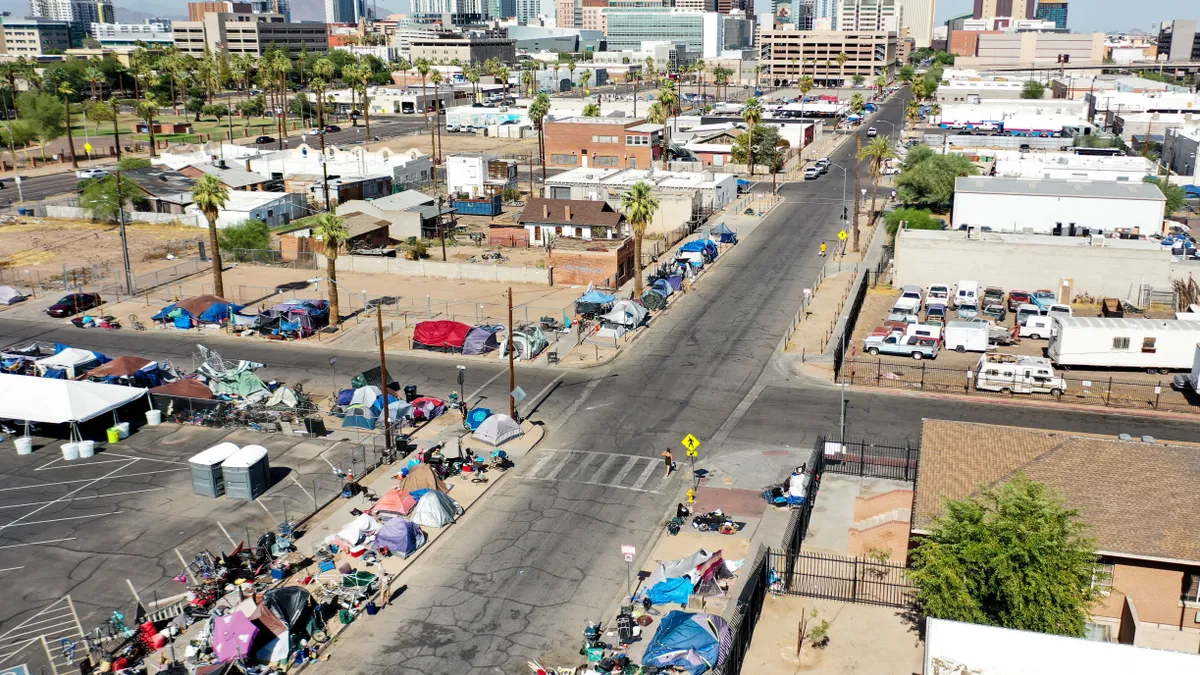 An aerial view shows people walking past a homeless encampment in the afternoon heat on July 21, 2022 in Phoenix, Arizona.