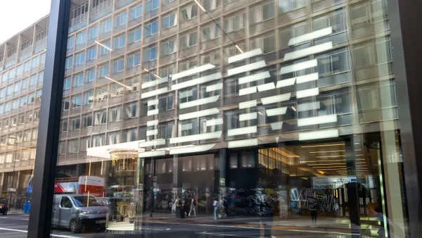 The IBM logo is pictured on the glass facade of a London office building.
