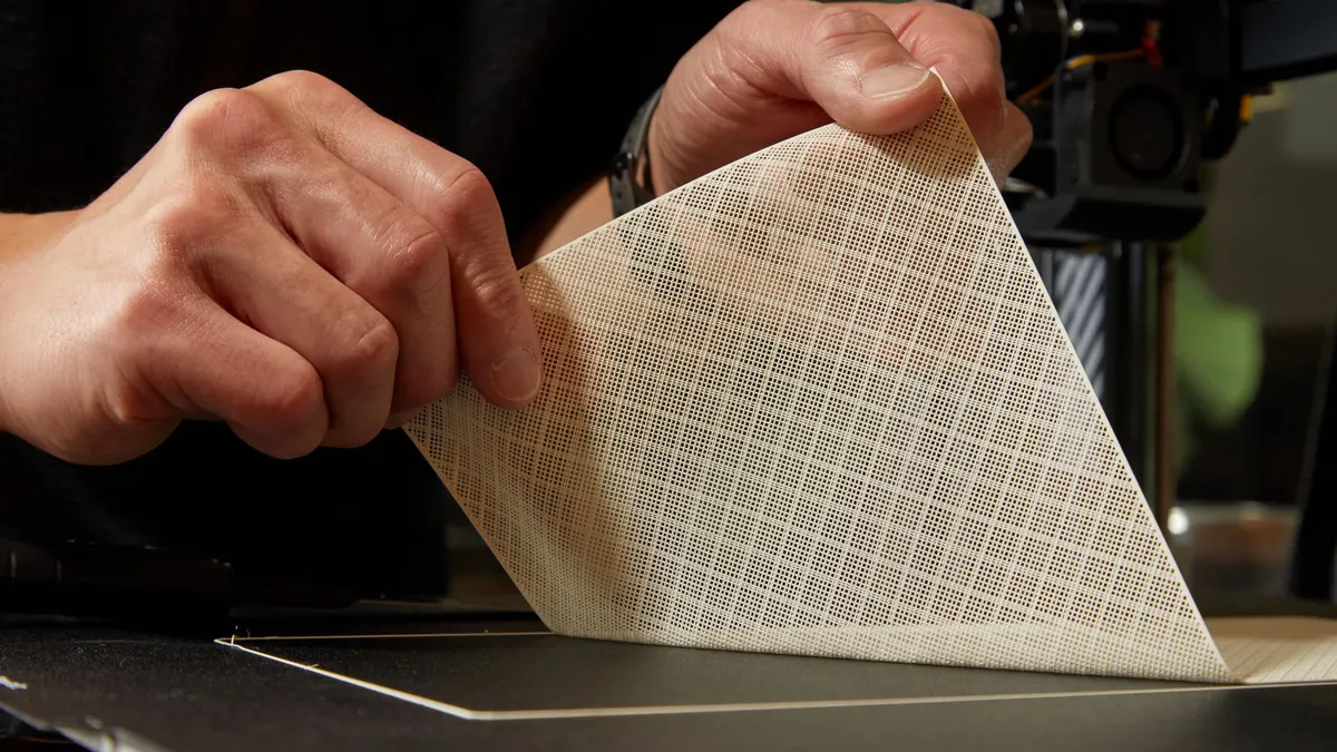 A printed textile swatch being removed from the build plate at Variloom