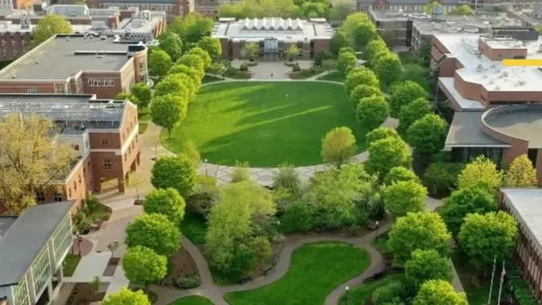 Aerial view of campus, with grassy quads framed by rows of buildings.