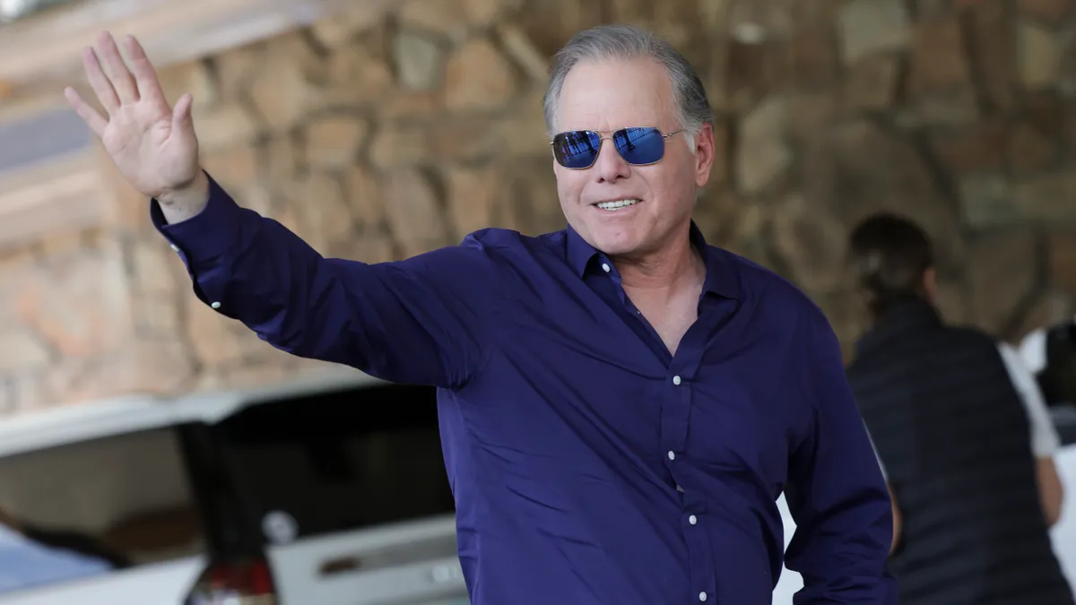 David Zaslav, president and CEO of Warner Bros. Discovery Inc., is seen in sunglasses and a blue shirt, waving.