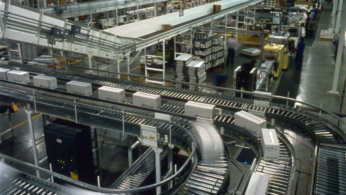 Boxes of microsoft roll down a conveyor.