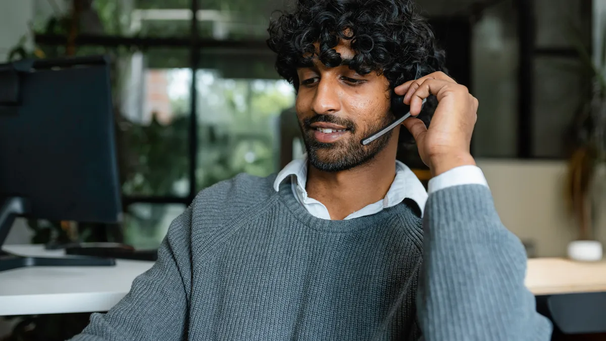 Person taking a call at a call center desk.