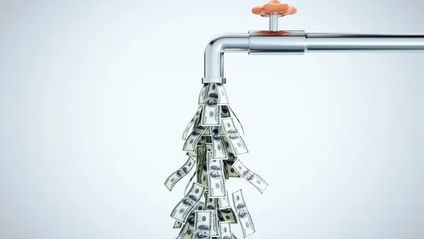 Water tap dripping dollar bills