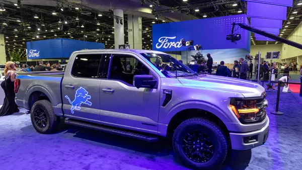 A Ford F-150 on display at the 2025 Detroit Auto Show with a Detroit Lions NFL team logo on the right rear door.