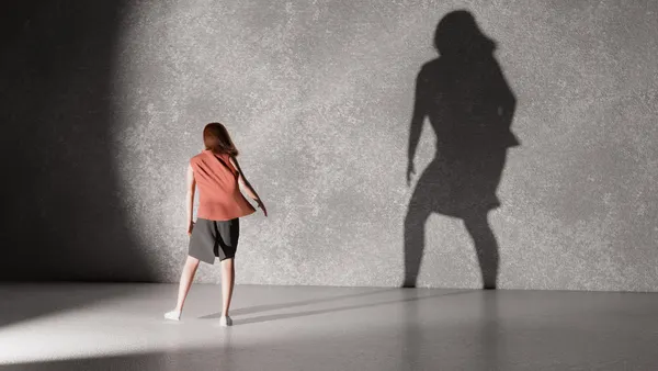 woman standing in front of wall casting shadow