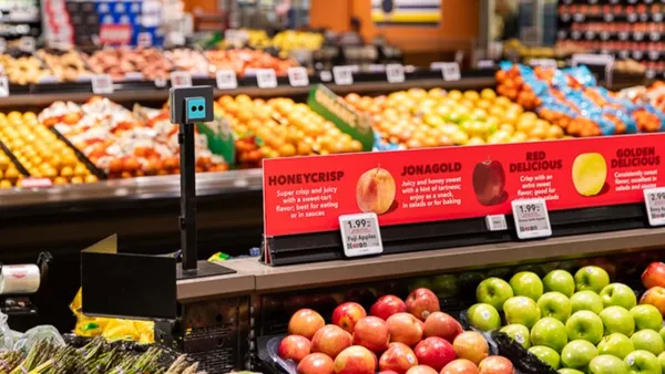 Sensors mounted on a pole in front of produce in a grocery store