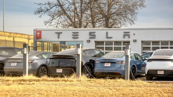Multiple Tesla electric cars parked at a charging station in front of a Tesla service center building in Calgary, Alberta, on Jan. 21, 2026.