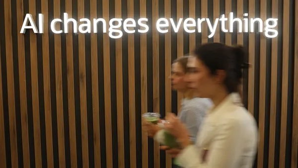 Sign above conference attendees reads "AI changes everything" referring to artificial intelligence