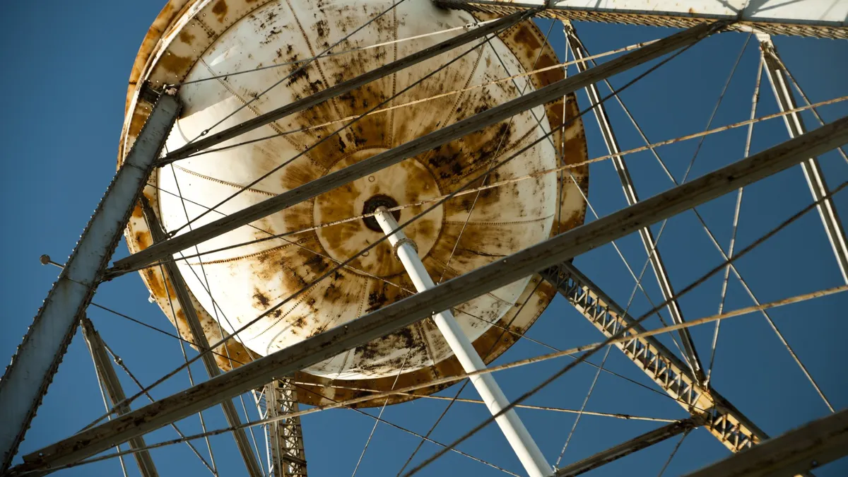 Underneath a rusty water tower.