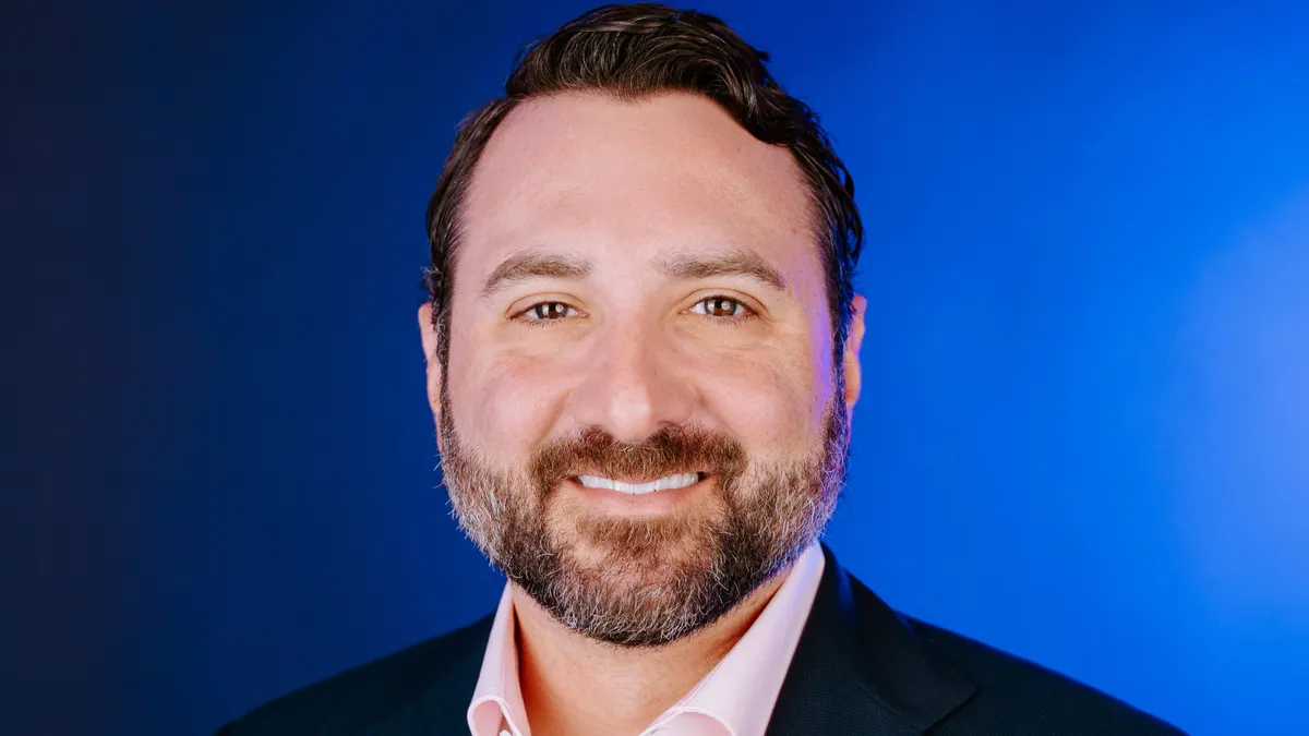 A photograph of a person wearing a navy blue suit.