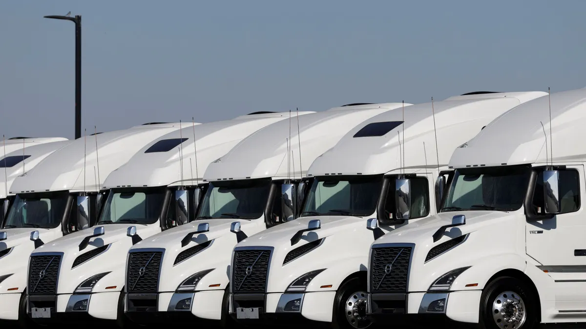 Heavy-duty trucks are displayed at a dealership