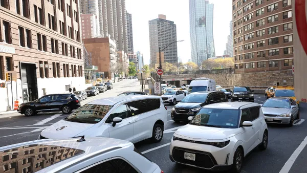 Bumper-to-bumper cars emerge from a tunnel onto a midtown Manhattan street.