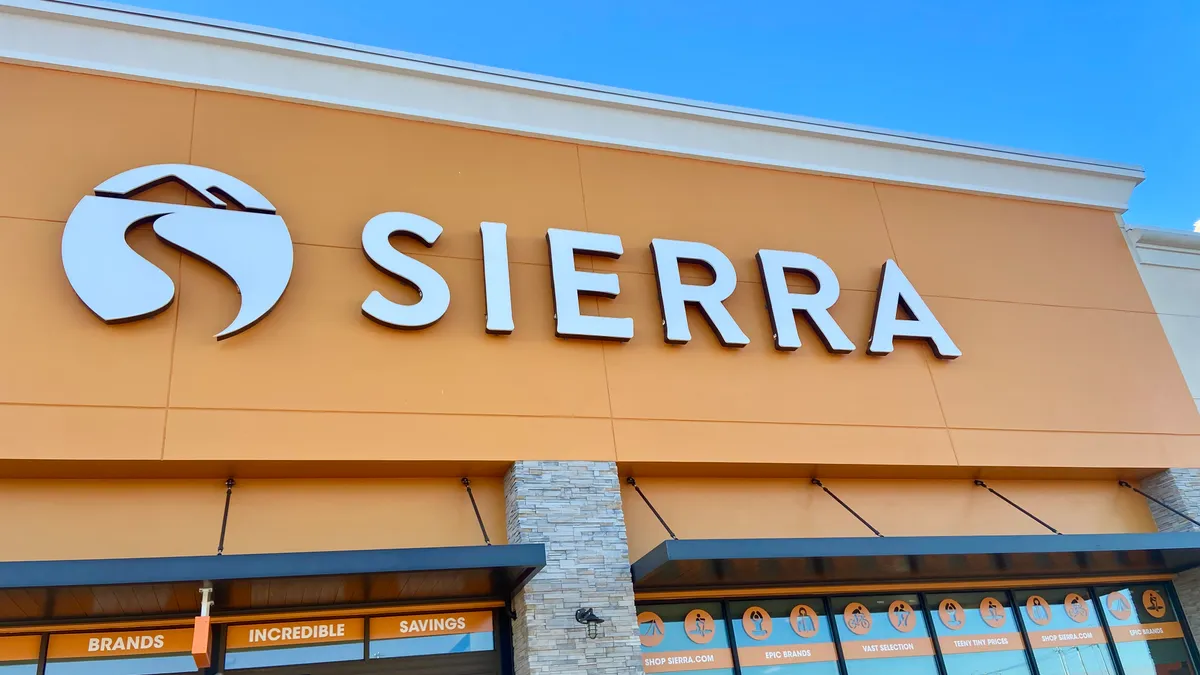 A mango-colored storefront says "Sierra" in white capital letters, against a bright blue sky.