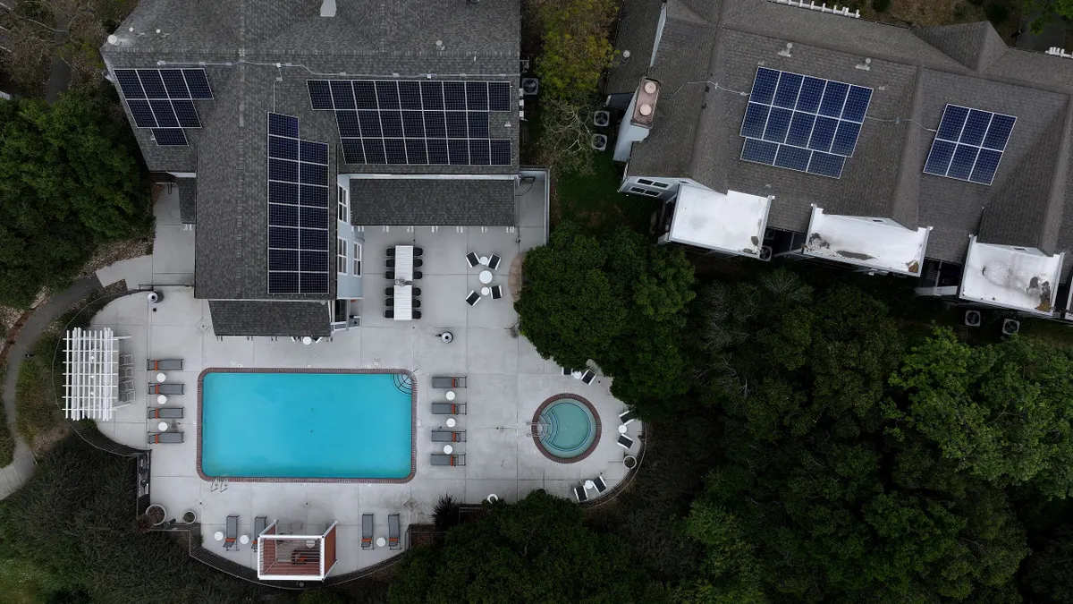 Solar panels are seen on the roof of an apartment complex