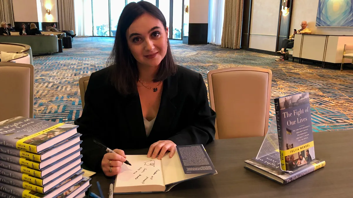 photo of Iuliia Mendel, former Ukrainian press secretary, signing books