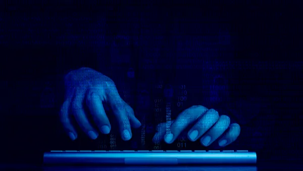 Digital code data numbers and secure lock icons on hacker's hands working with keyboard computer on dark blue tone background.